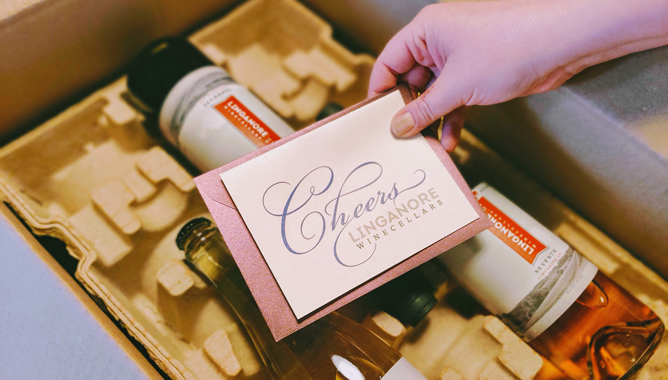 woman holding card over open box of linganore wines