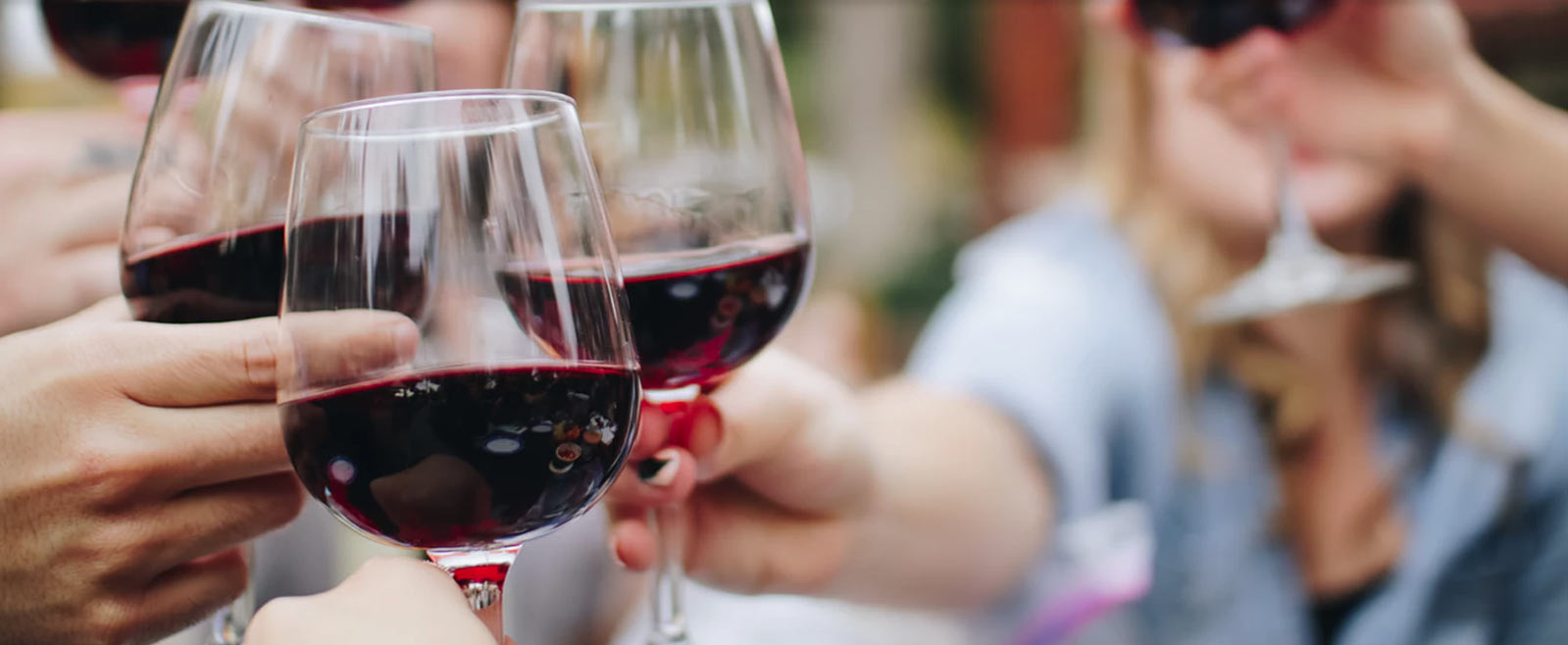 group of friends saying cheers with glasses of red wine